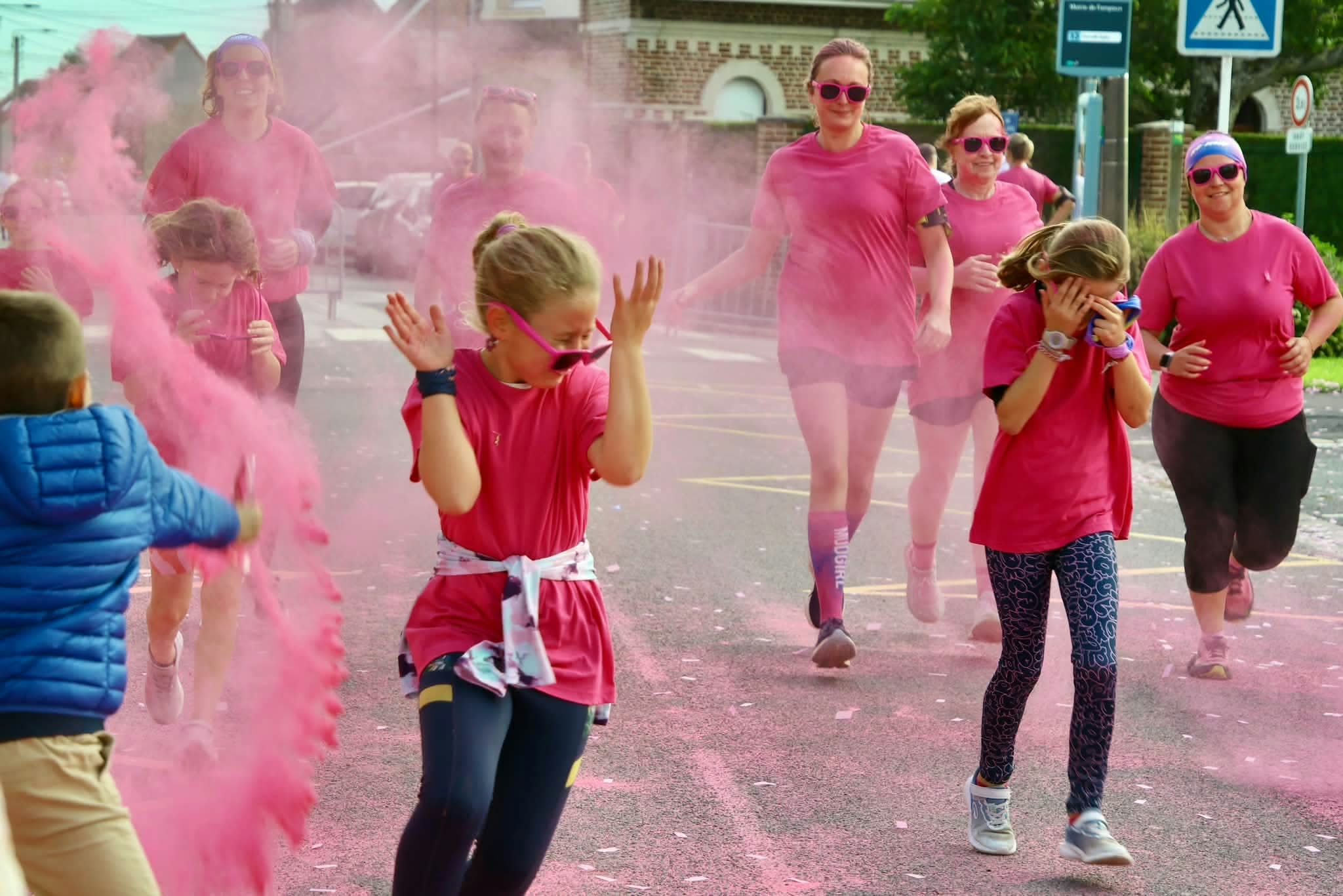 Teilnehmende durchqueren eine rosa Farbwolke beim Color Pink Run.